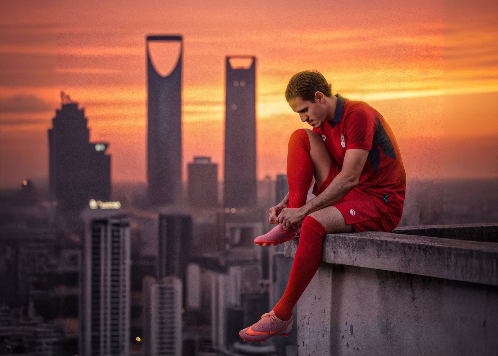 ภาพที่สมจริงหรือนามธรรม? โปสเตอร์อย่างเป็นทางการของ DAMAC: ผู้เล่นนั่งบนขอบหลังคาเพื่อผูกเชือกรองเท้า